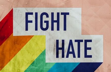 Schriftzug in Grossbuchstaben "Fight Hate" vor Regenbogenhintergrund