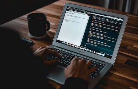 Hände, die man beim Prompten am Laptop sieht