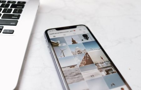 Ausschnitt von Laptop neben Handy mit Insta-Display