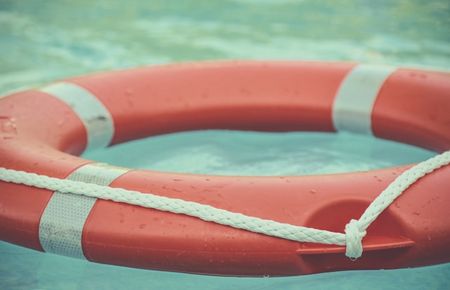 orangeroter Rettungsring auf türkisfarbenem Wasser