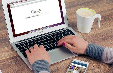 Laptop, weibliche Hände mit rotem Nagellack, Bildschirm zeigt Google-Schriftzug