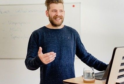 Mann steht am Rednerpult und spricht