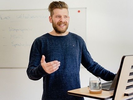 Mann steht am Rednerpult und spricht mit Gestik der Hand