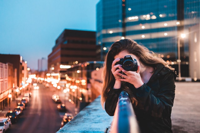 Frau hält eine Fotokamera in der Hand.