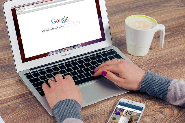 Hände auf der Tastatur, Google auf dem Bildschirm